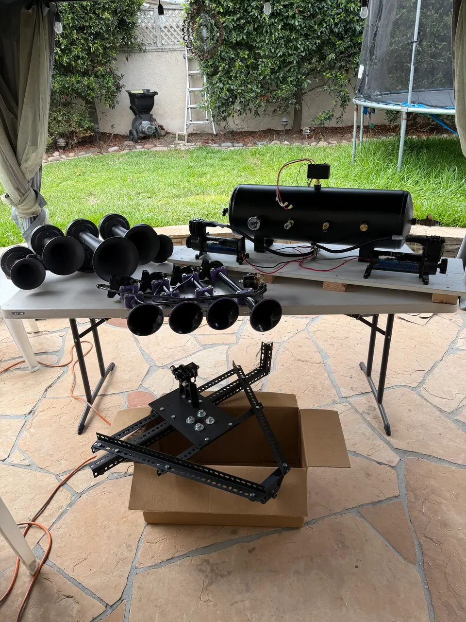 Everything laid out before installation: horns, air tank, compressors and the cage