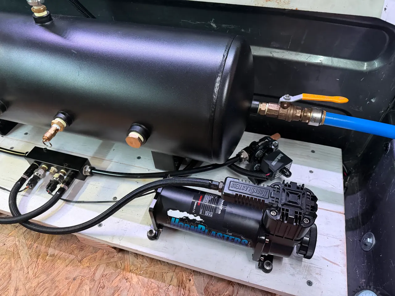 The automatic drain valve and plumbing on the 8-gallon tank